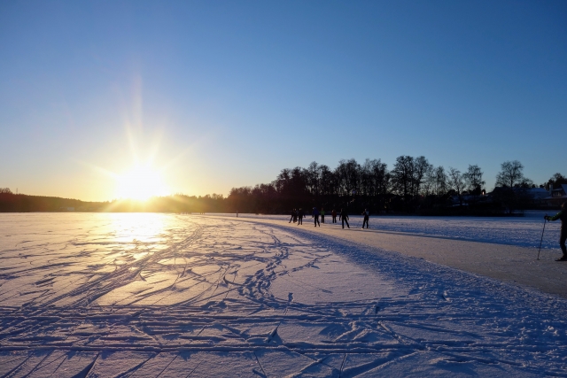 冬の雪化粧の中で顔を出す太陽の写真